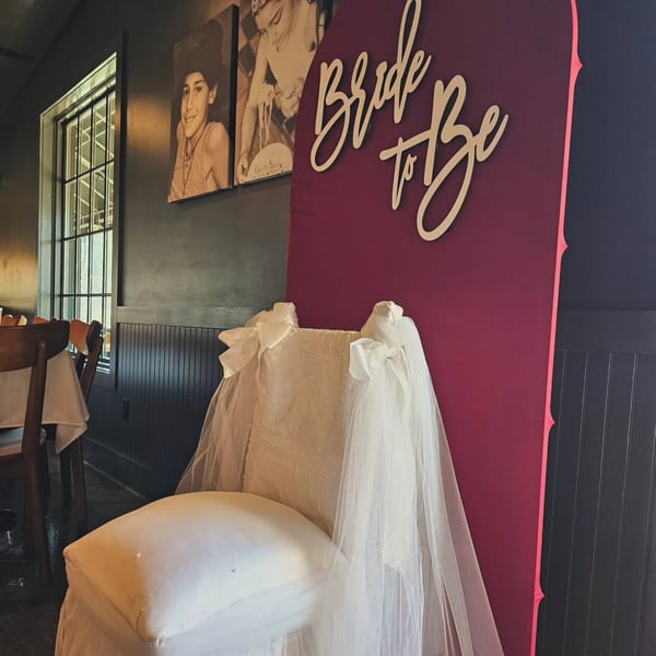 White decorated chair and a burgundy 'Bride to Be' sign in a restaurant.