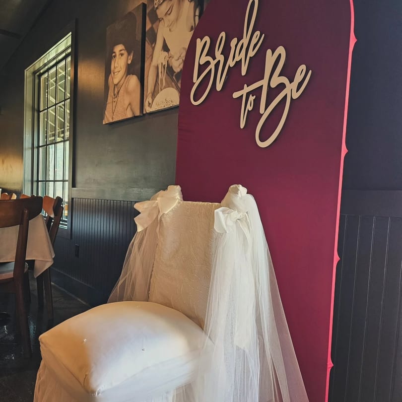 White decorated chair and a burgundy 'Bride to Be' sign in a restaurant.